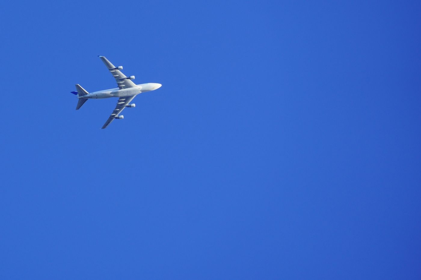 A passenger jet flying across a clear blue sky