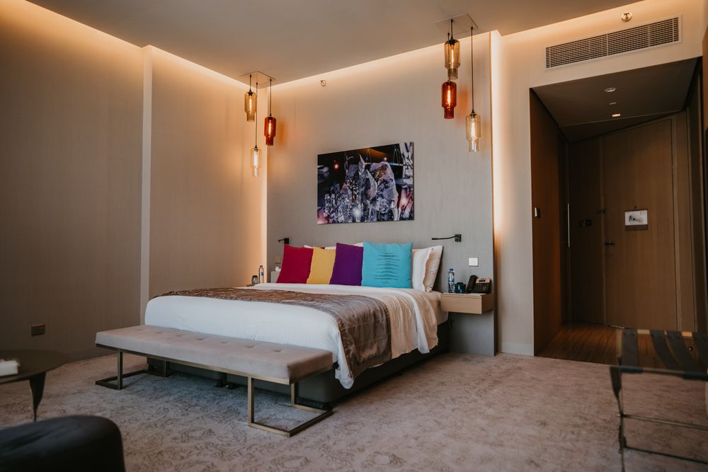 A warm, modern hotel room with a made bed